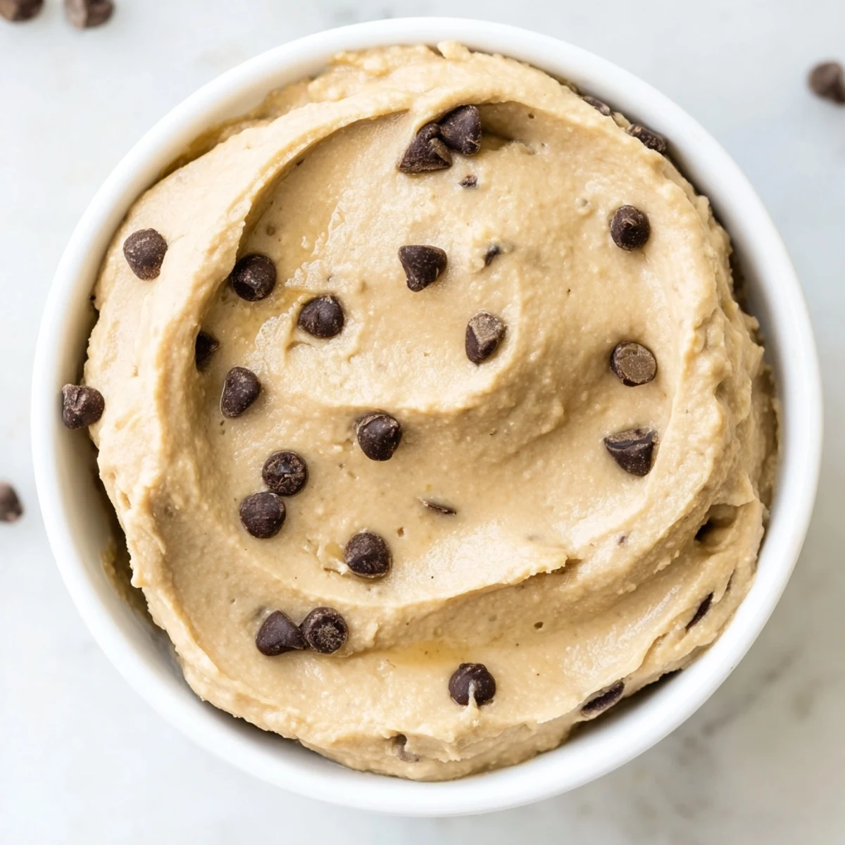 Gluten-free Chocolate Chip Cookie Dough Hummus served with pretzels and graham crackers on a rustic table.