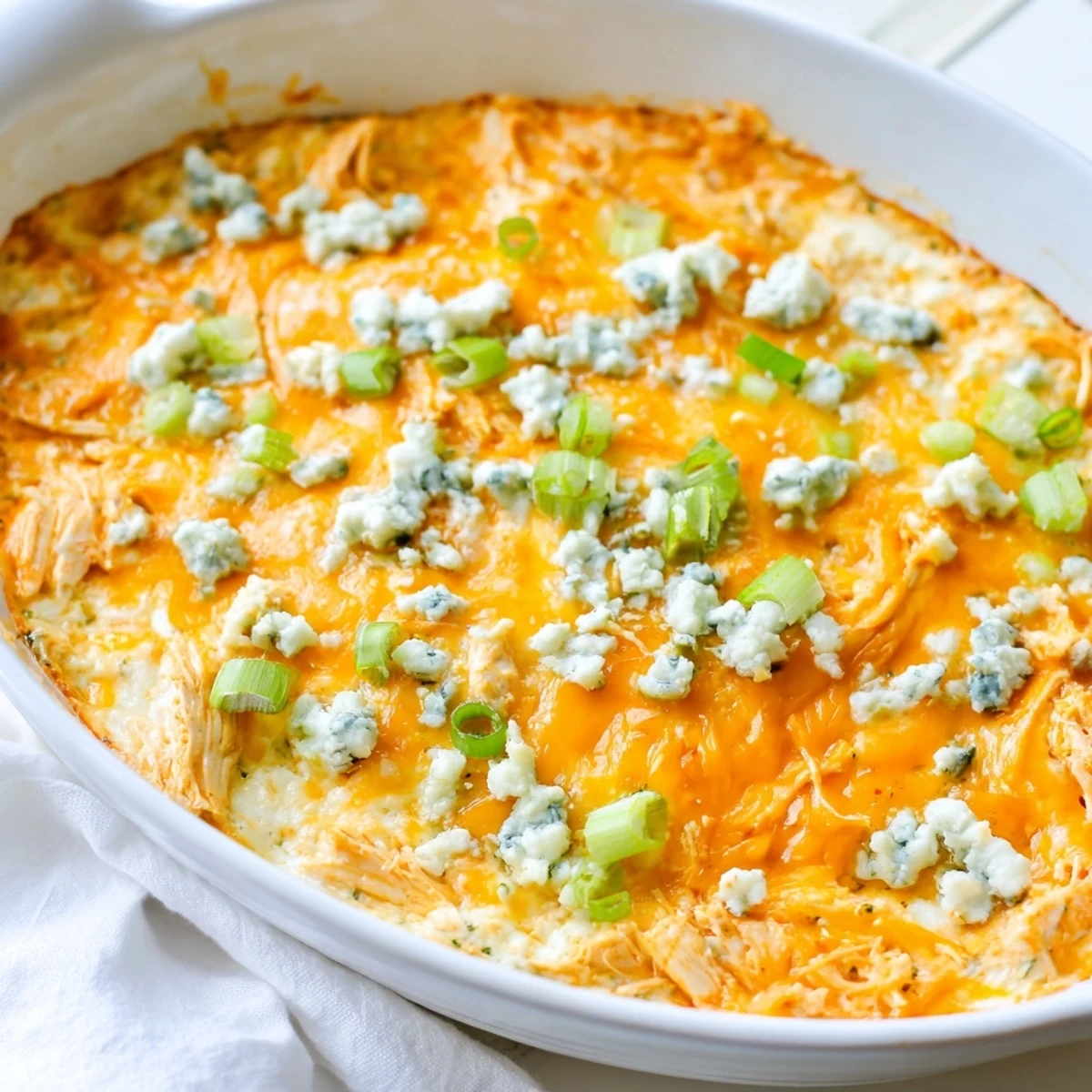A festive platter of Spicy Buffalo Chicken Dip garnished with scallions, surrounded by crunchy tortilla chips for game day.