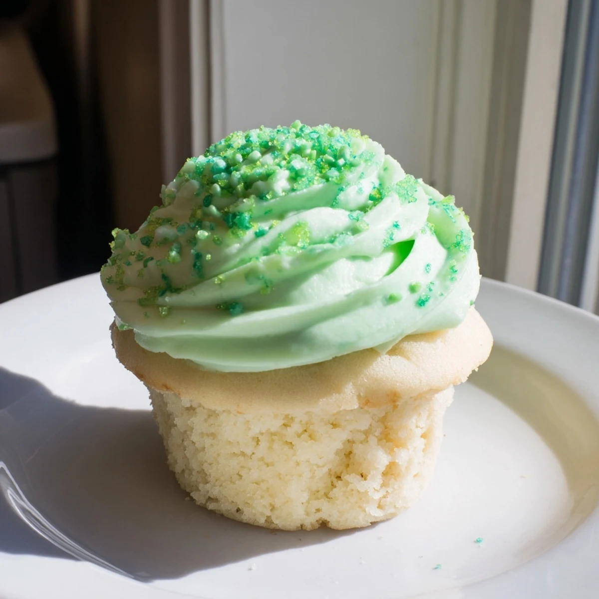 Four Shamrock Shake Cupcakes topped with piped mint frosting and green sprinkles. 