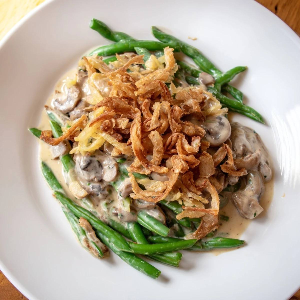 A spoonful of Green Bean Casserole with Crispy Onions lifted from the dish, revealing the rich, creamy sauce and crispy texture of the onions.