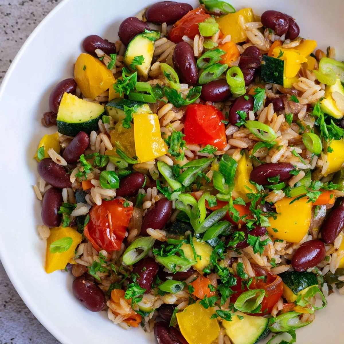 Steam rises from a pot of Mardi Gras Veggie Jambalaya with Beans, showing the fluffy rice and spices in a festive Southern style.