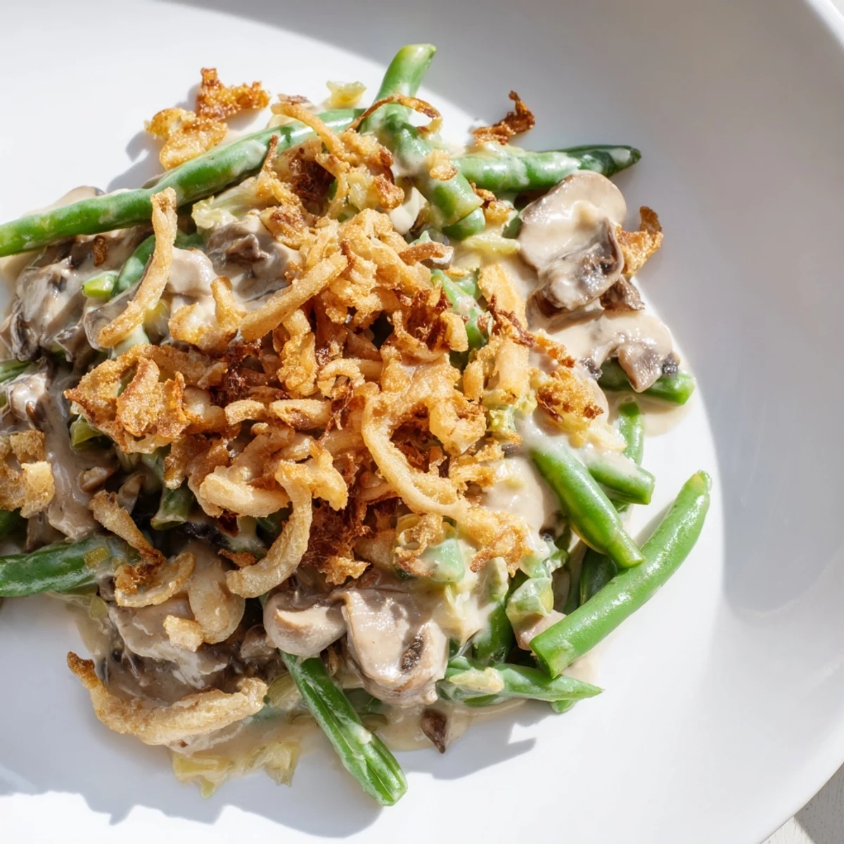 Green Bean Casserole with Crispy Onions resting on a wooden table, featuring tender beans and crunchy golden onions.