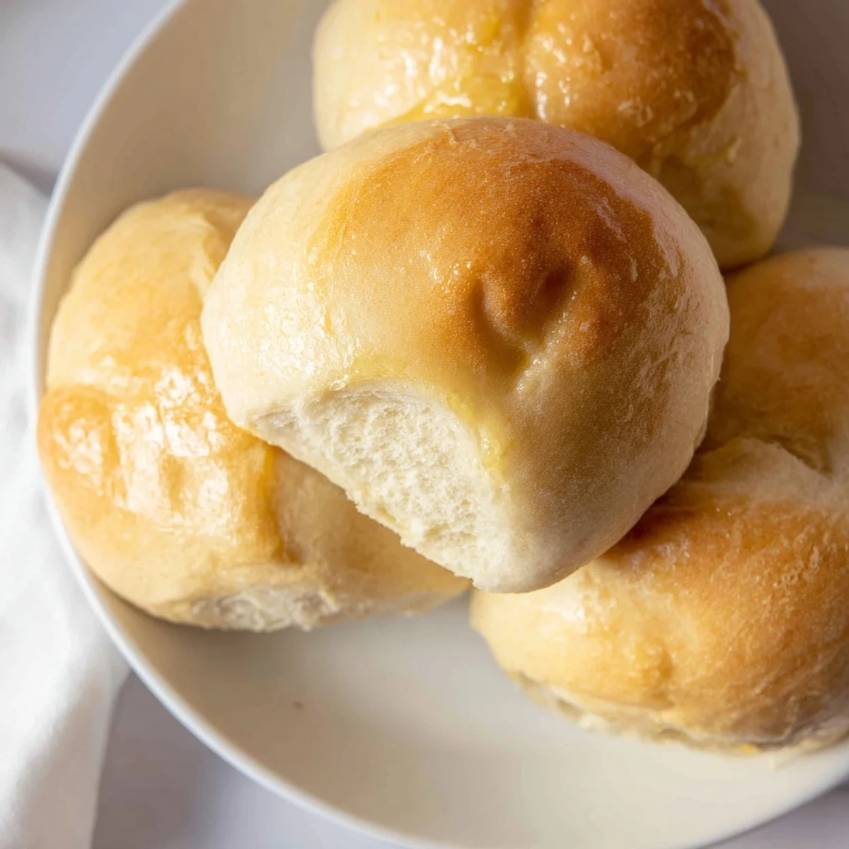 Twelve soft, fluffy Best Vegan Dinner Rolls arranged in a 9x13-inch baking dish, slightly golden on top and ready to serve.