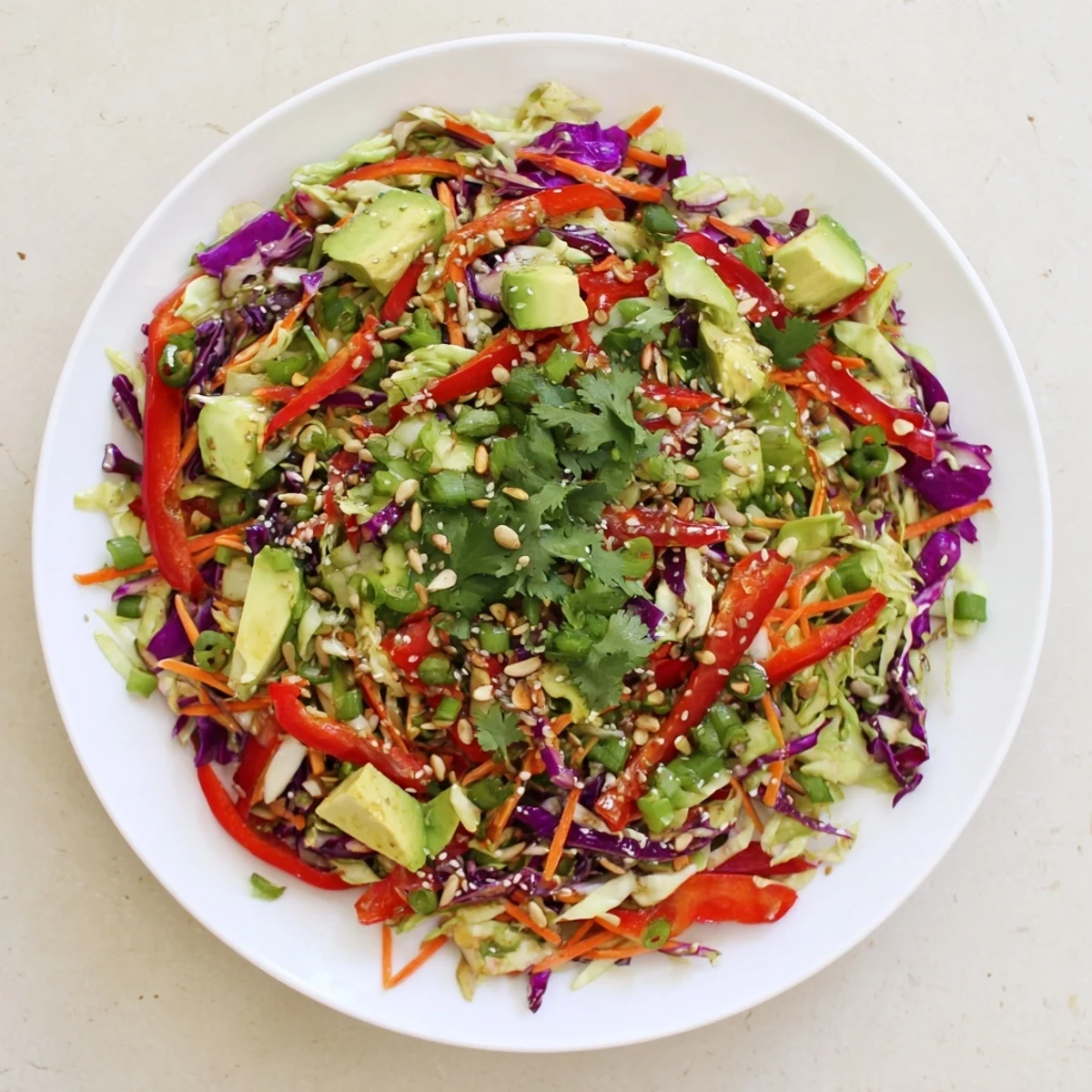 Close-up of Avocado Cabbage Salad garnished with sesame seeds and fresh cilantro, highlighting its refreshing, crunchy texture.