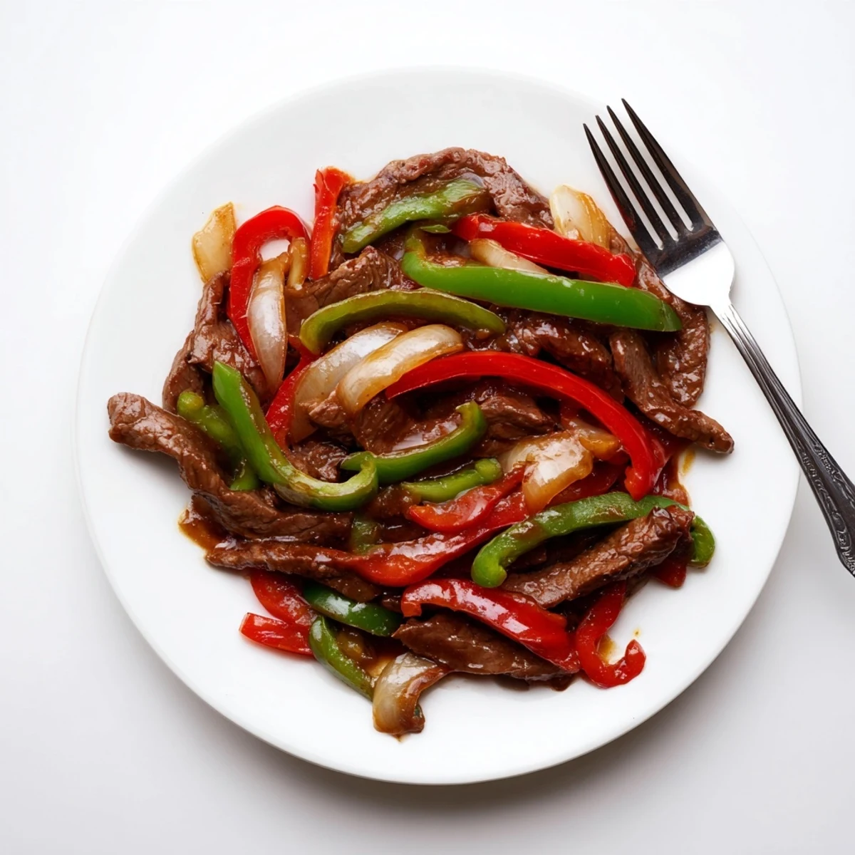 The Sizzling Chinese Pepper Steak With Onions is plated hot with colorful peppers and onions, offering a savory, peppery aroma perfect for a quick weeknight dinner.