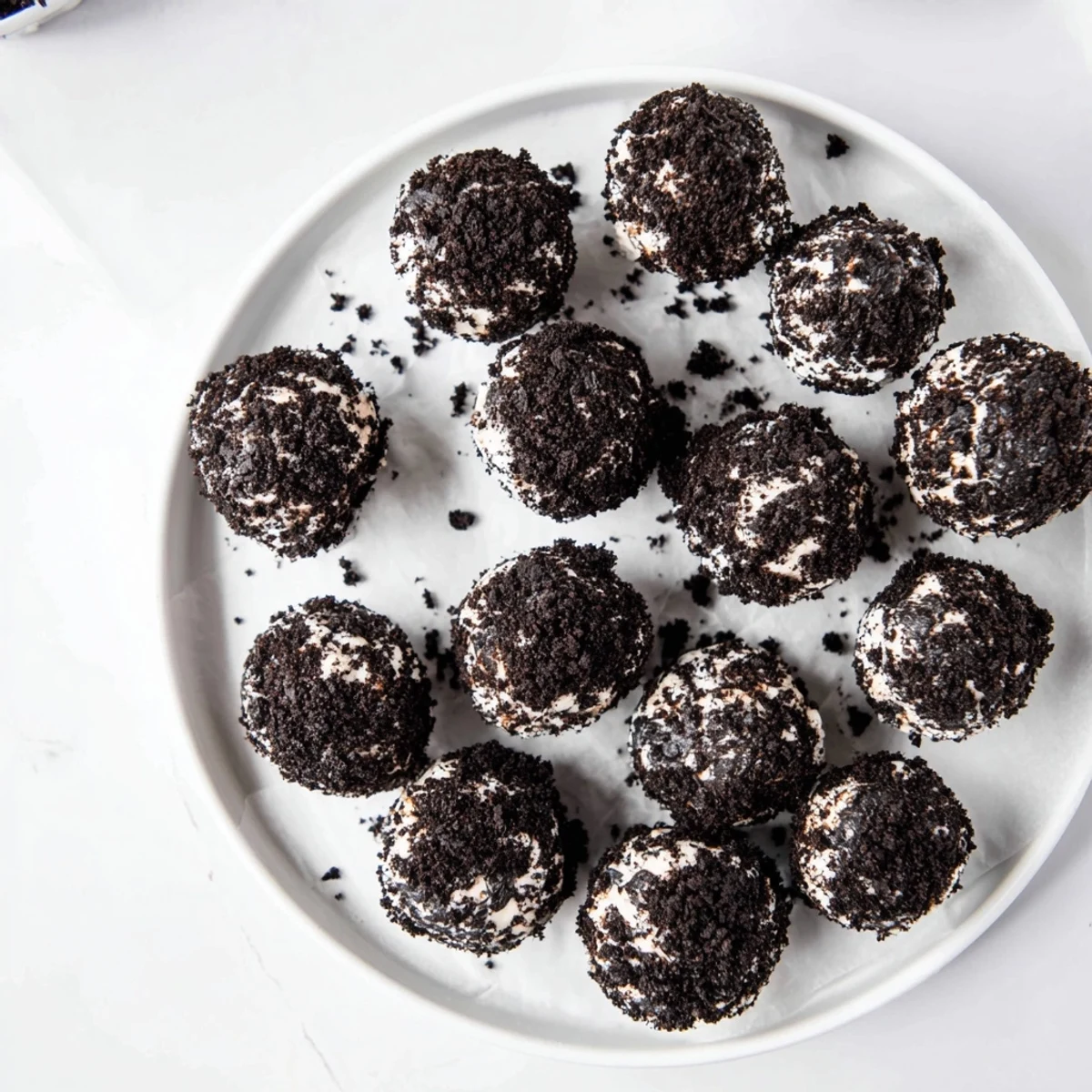 No bake cream cheese Oreo protein balls drizzled with chocolate on parchment paper, perfect for snacking.