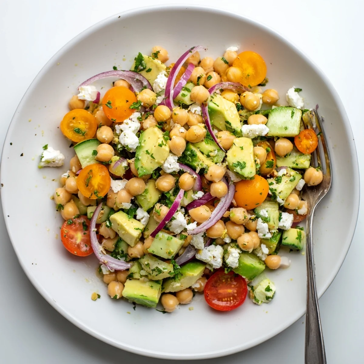 A bright Chickpea Feta Avocado Salad is tossed in zesty lemon dressing and topped with crumbled feta cheese.
