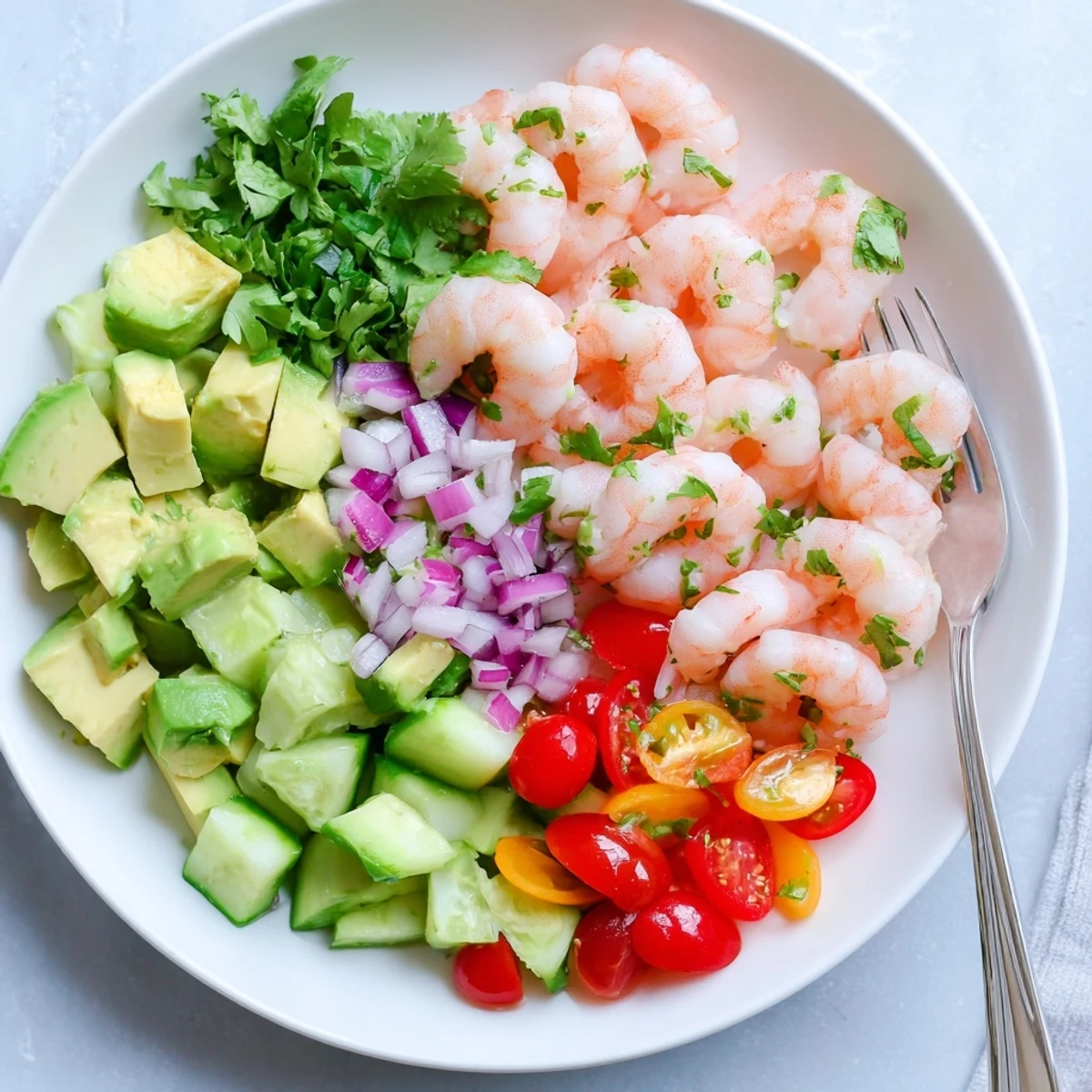 Close-up of Healthy Shrimp Avocado Salad with tender shrimp, red onion, and cilantro, ready for a light lunch or dinner.