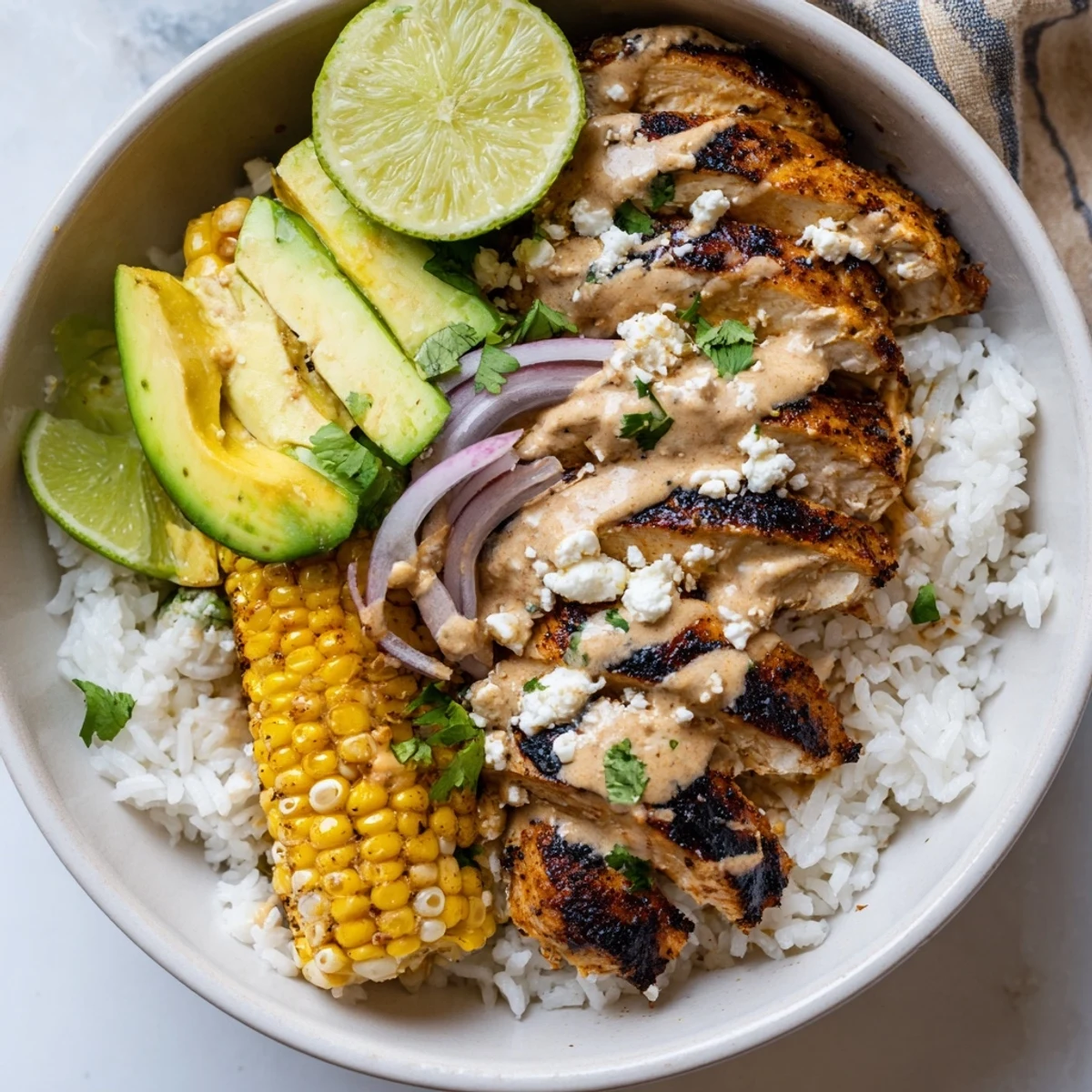 Street corn chicken rice bowl featuring grilled chicken, creamy corn, and fresh avocado slices