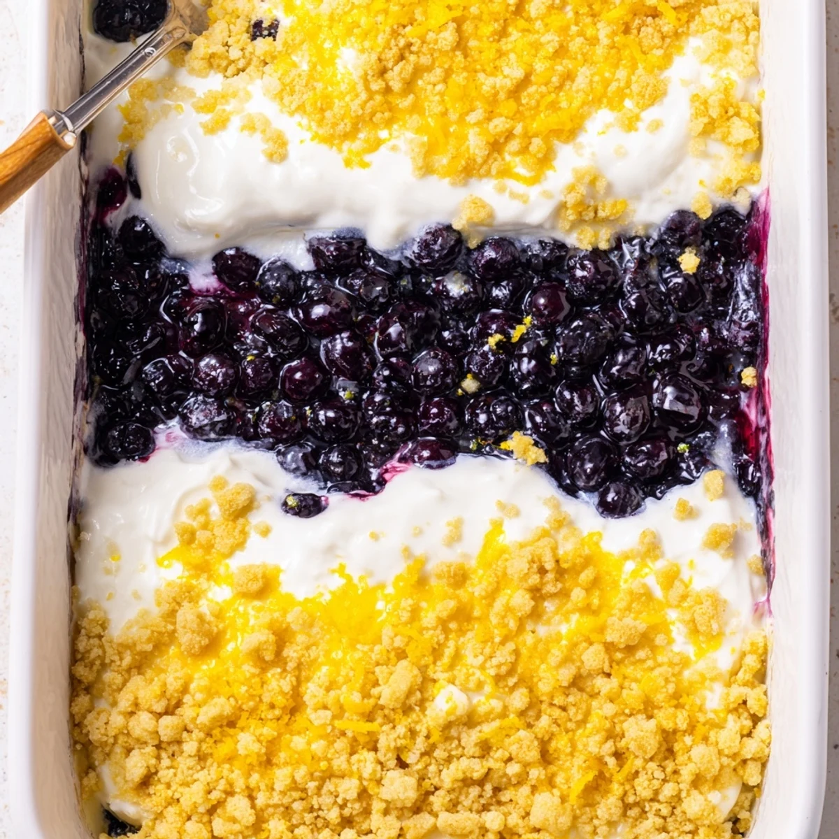 Bubbling 9x13 pan of lemon blueberry cheesecake dump cake with golden buttery topping