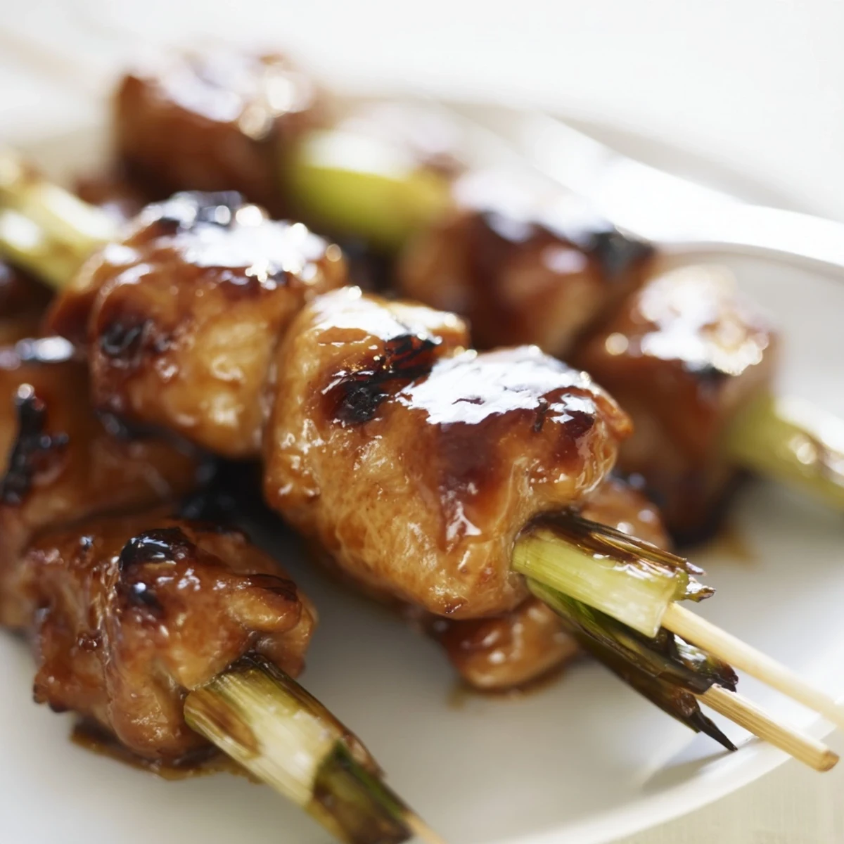 Golden grilled Japanese chicken yakitori featuring charred edges and succulent scallion pieces