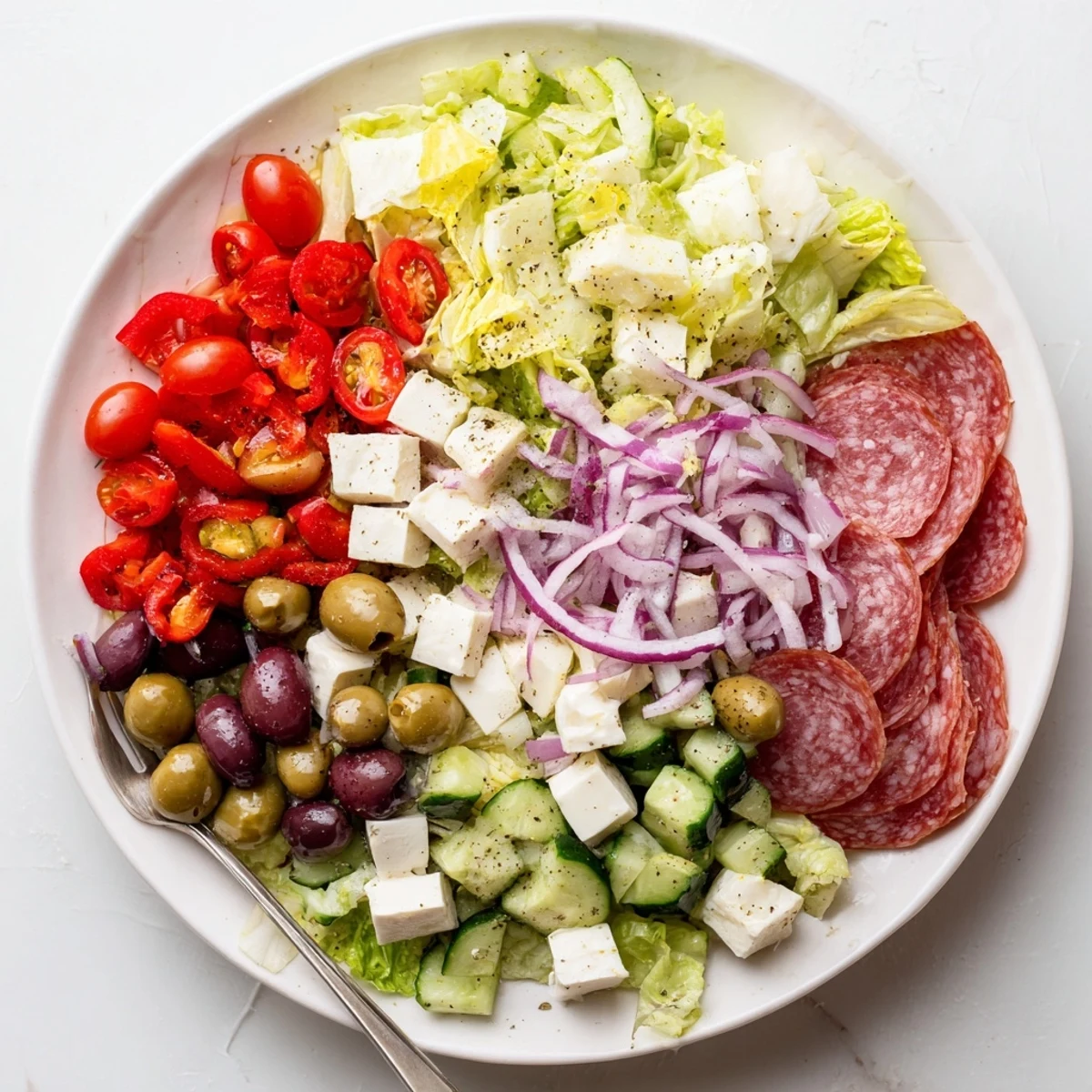 Vibrant Italian Chopped Salad tossed with tangy homemade dressing and topped with shaved Parmesan cheese