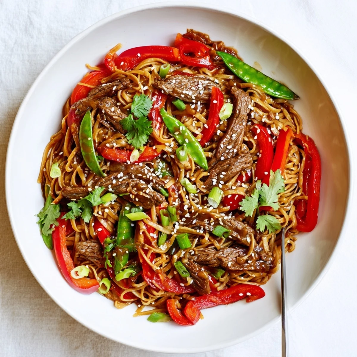 Glossy sticky beef noodles tossed with colorful vegetables in a rich sweet-savory sauce