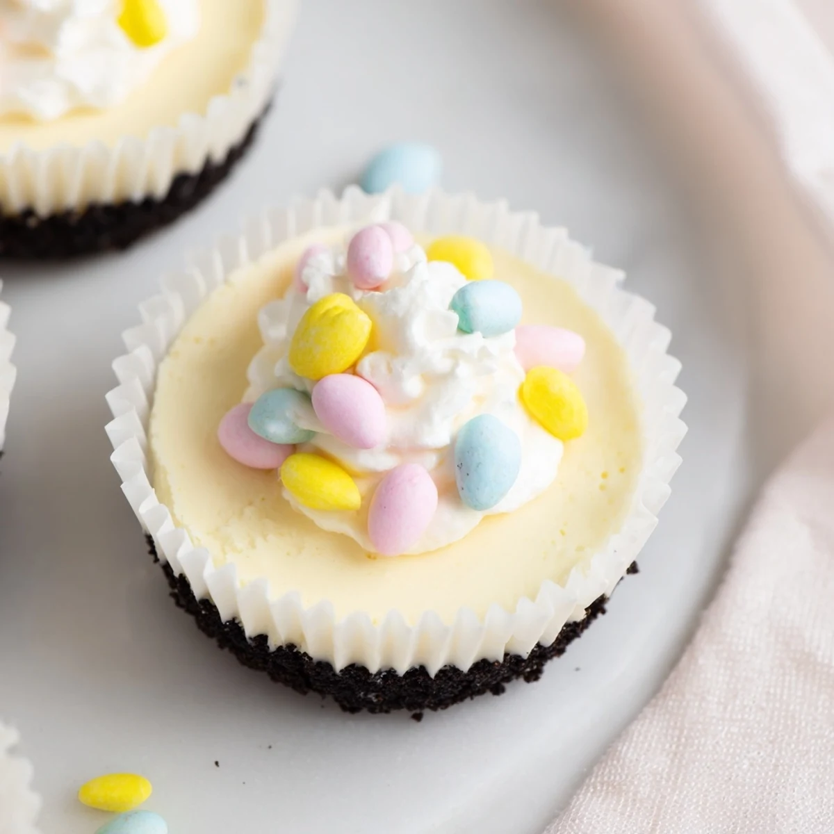 Festive Easter Cadbury Mini Cheesecakes featuring smooth vanilla filling and crushed Cadbury Mini Egg toppings