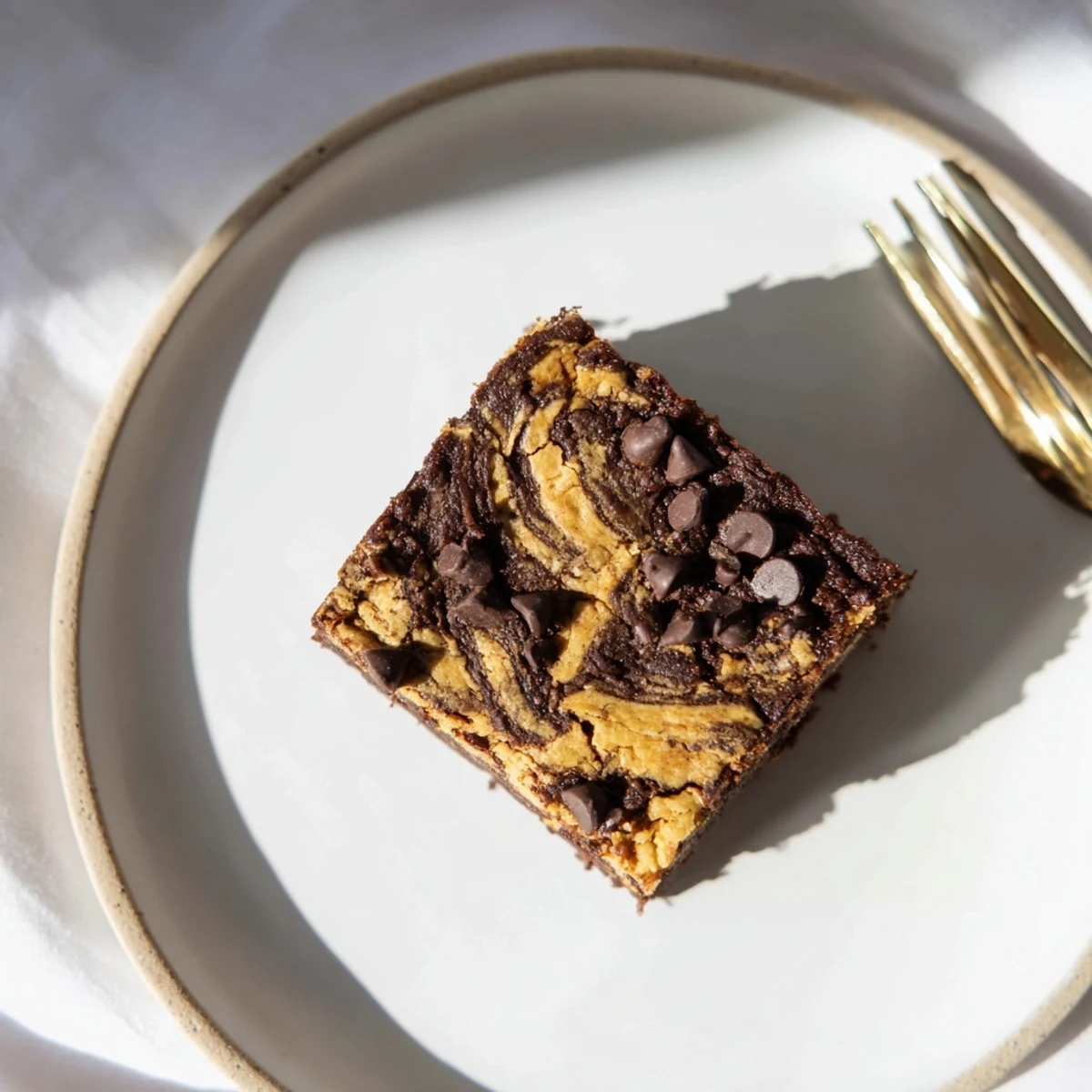 Freshly baked banana bread brownie bars cooling on wire rack with melted chocolate chips visible