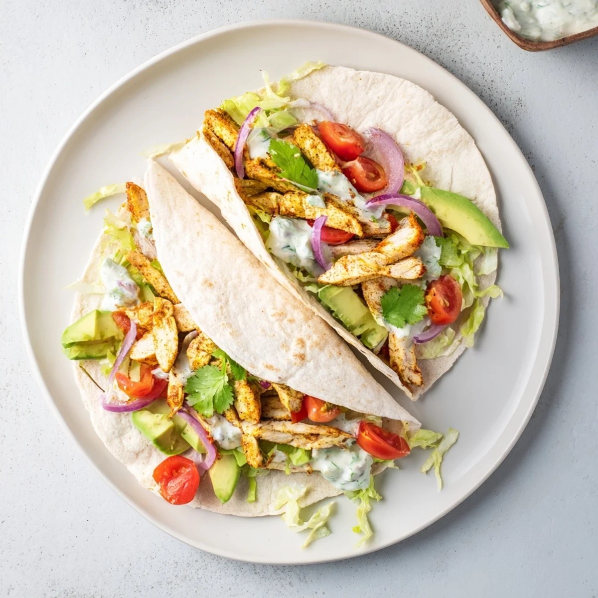 Spicy chicken avocado wraps rolled with creamy avocado slices crisp lettuce and zesty lime