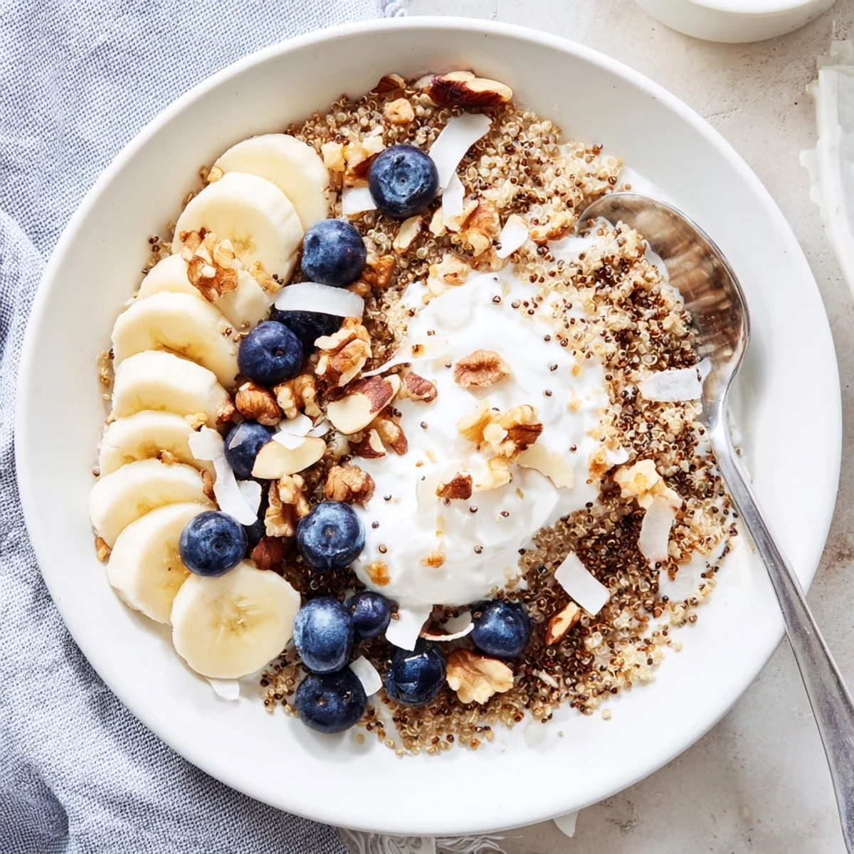 Protein-packed blueberry quinoa breakfast bowl drizzled with honey and sprinkled with coconut flakes