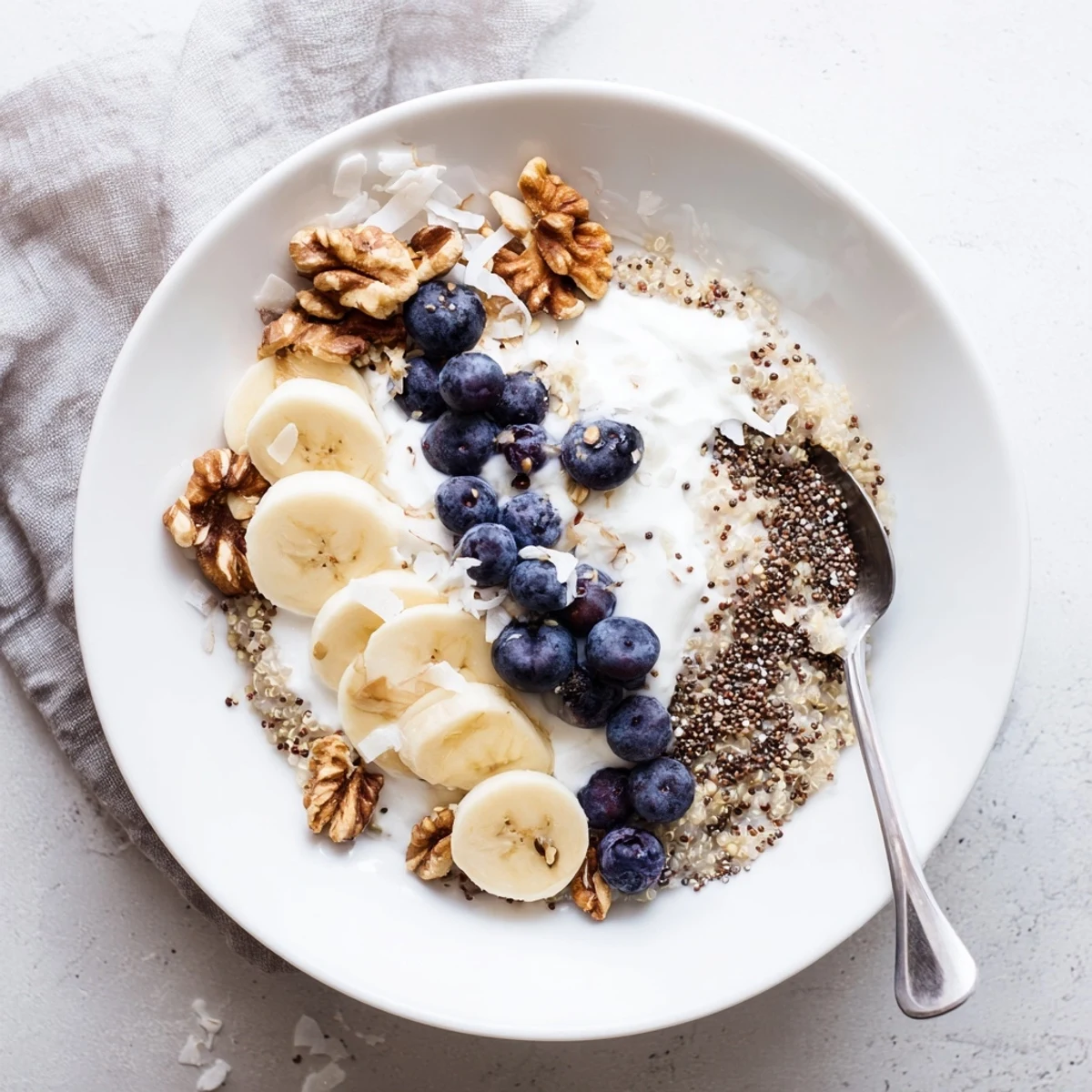 Golden quinoa breakfast bowl with yogurt, sweet blueberries and chia seed garnish in rustic bowl