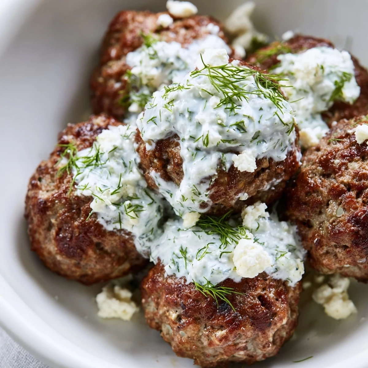 Golden pan-fried Greek meatball bowl served over rice with fresh cherry tomatoes