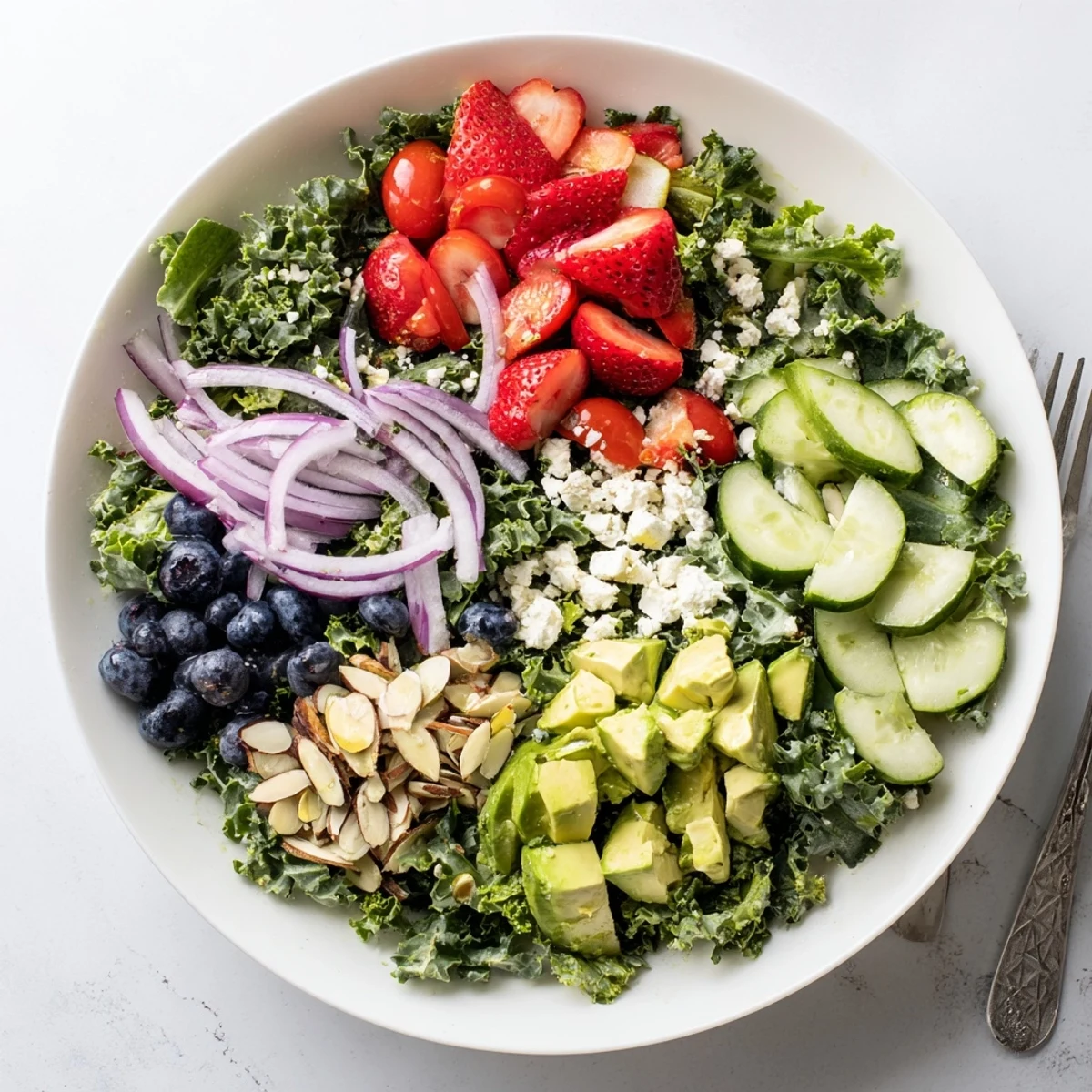 Fresh summer kale salad in a bowl drizzled with lemon-honey vinaigrette