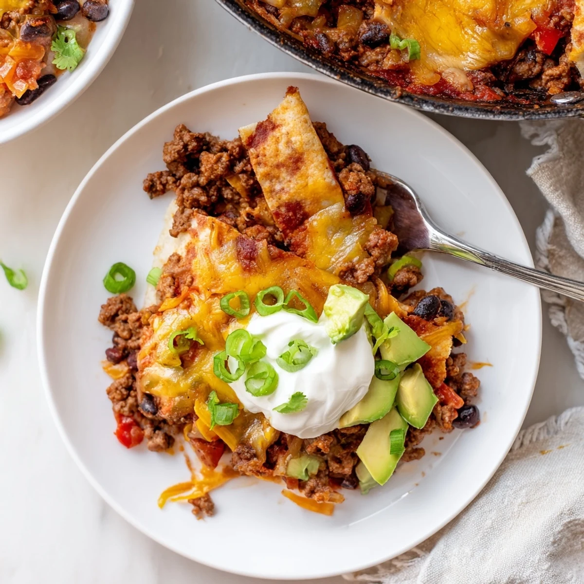 Beef Skillet Enchiladas bubbling with melted cheese in a cast-iron skillet