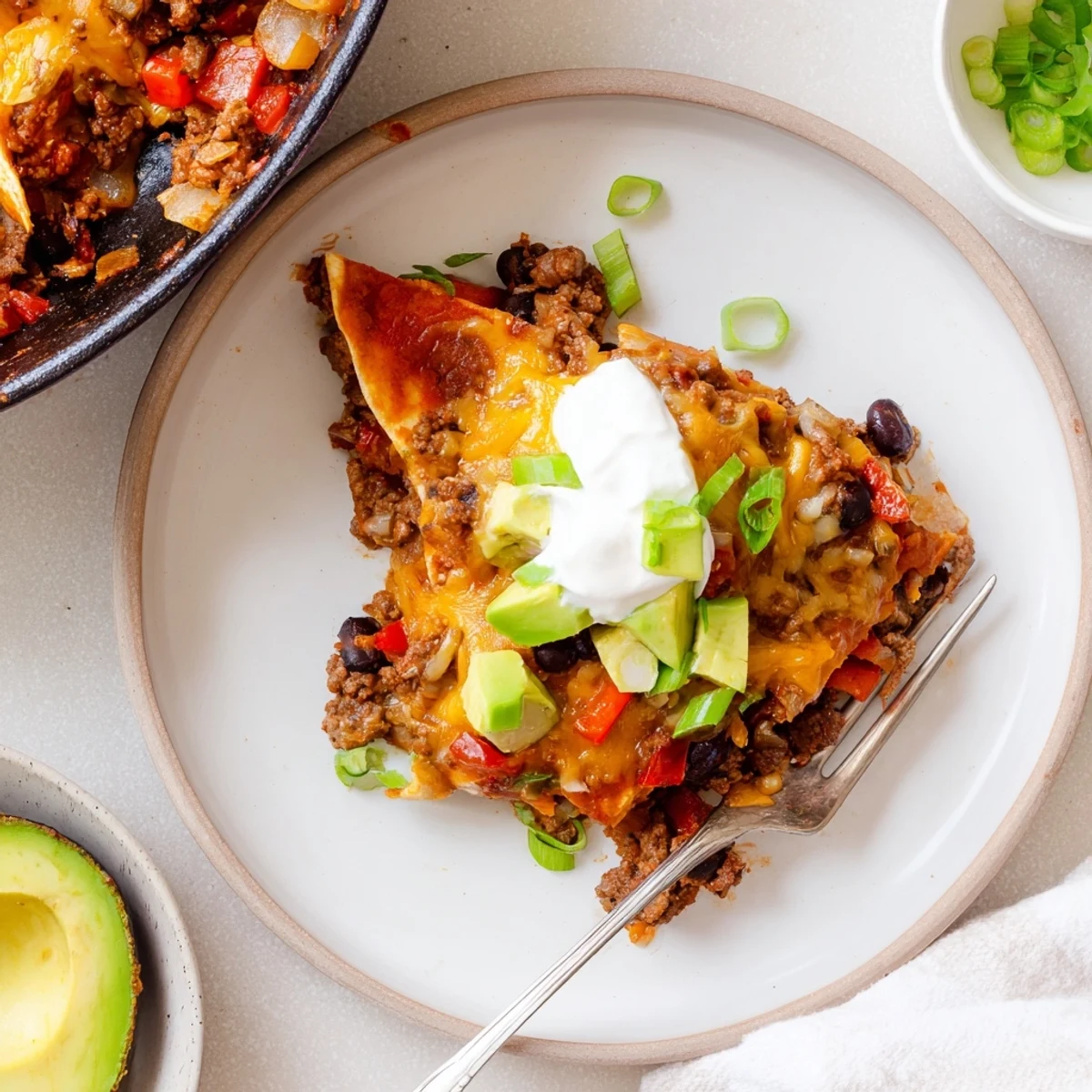 Hearty Beef Skillet Enchiladas layered with corn tortillas, spicy enchilada sauce