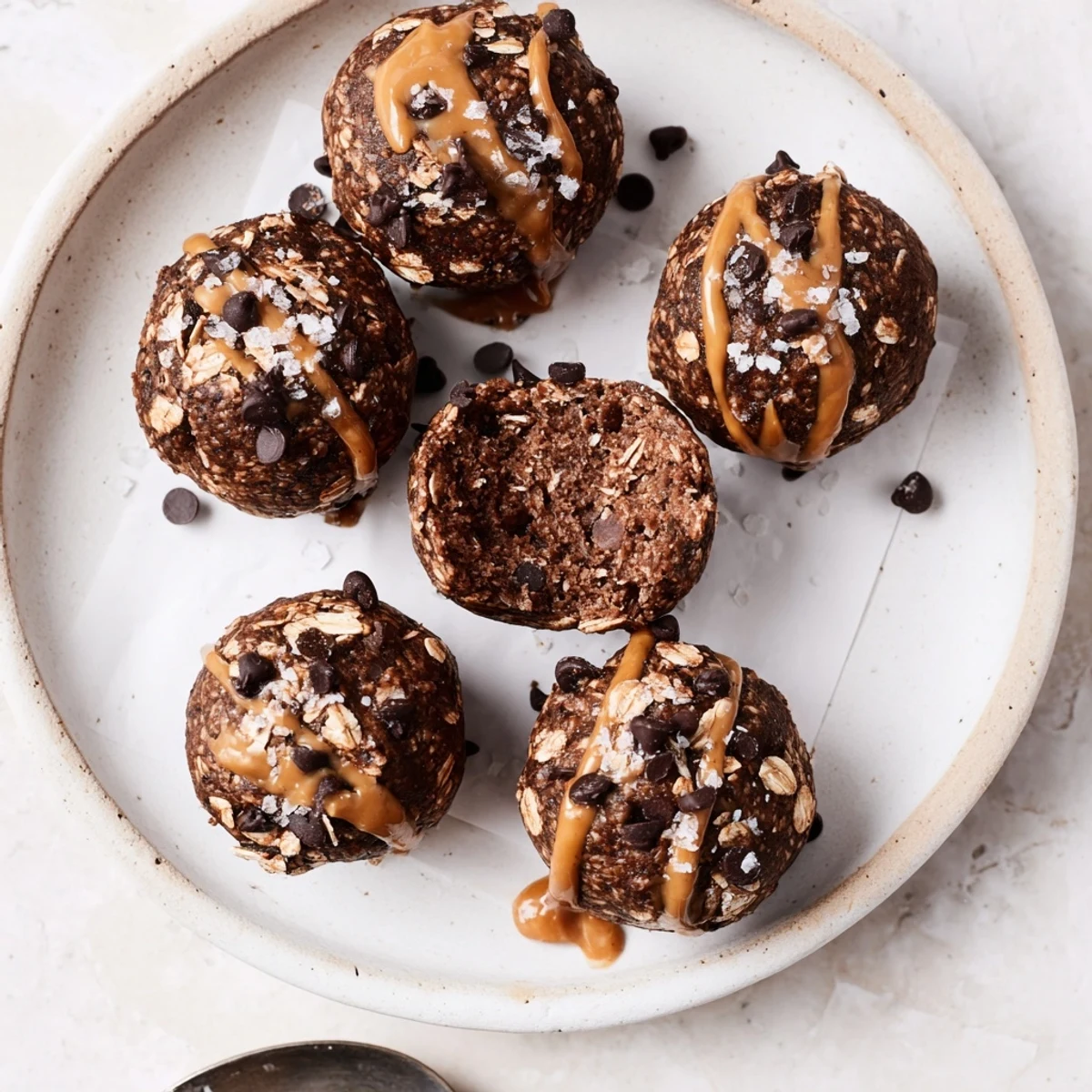 Close-up of hand-rolled Brownie Protein Bites studded with melting dark chips