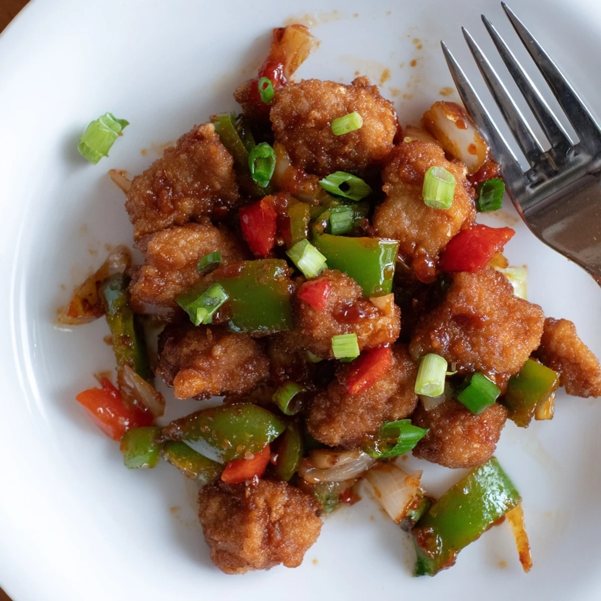 Flavorful Chilli Chicken Indo Chinese glistening in spicy sauce, served with rice.