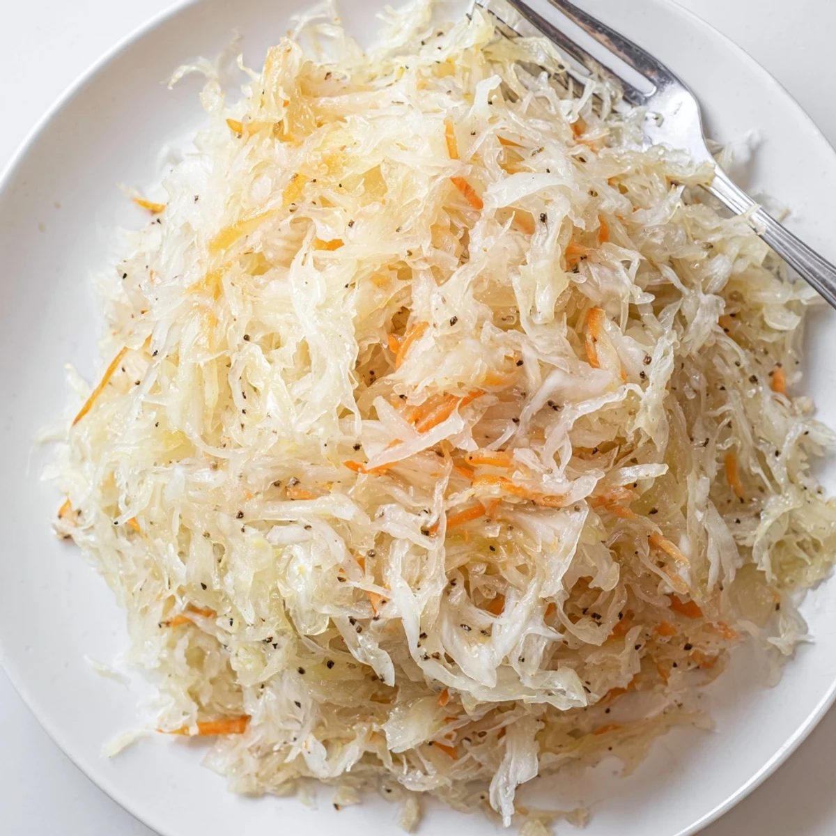 Golden fermented sauerkraut packed in glass jar with tangy brine and caraway seeds