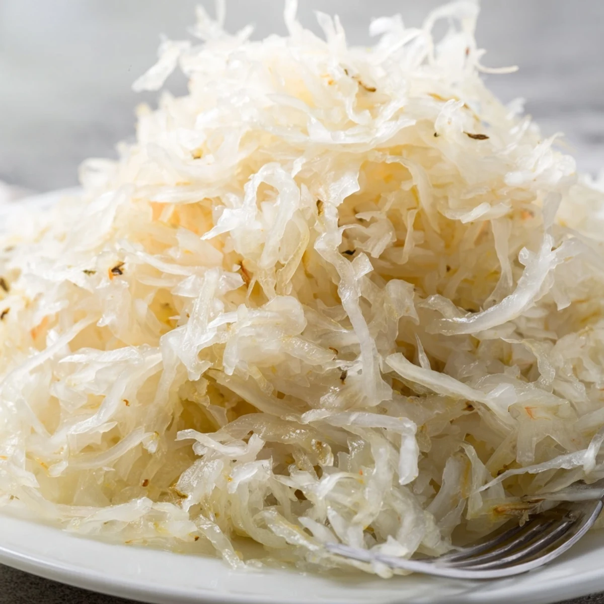 Homemade German sauerkraut displaying crisp shredded cabbage texture in ceramic fermentation crock