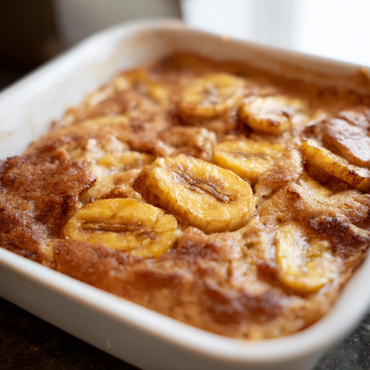 Freshly baked Southern Banana Cobbler drizzled with caramel sauce and served warm.