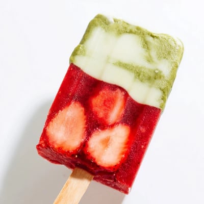 Stack of eight creamy Strawberry Matcha Latte Popsicles featuring a vivid pink strawberry base and smooth green matcha layer.  