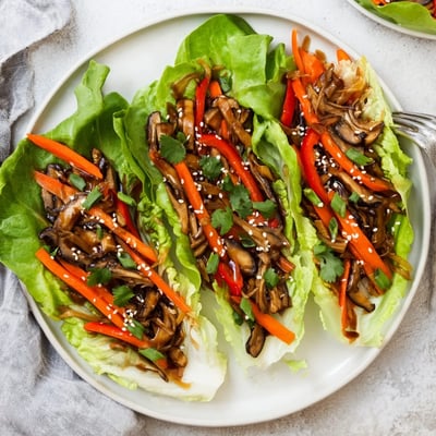 Golden sautéed shiitake mushrooms and colorful peppers tucked into buttery lettuce cups for a flavorful, gluten-free bite.