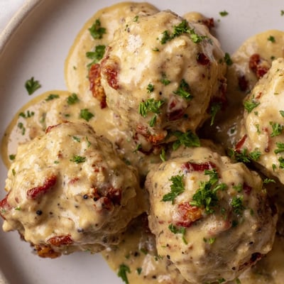 Tender, juicy chicken and sun-dried tomato meatballs are coated in a luscious, tangy mustard cream sauce, garnished with fresh parsley.