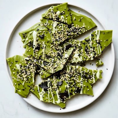 Elegant broken pieces of Black Sesame Matcha Bark reveal the crisp interior and glistening white chocolate edges.