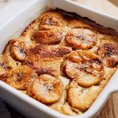 Warm Southern Banana Cobbler topped with fluffy biscuits and sliced ripe bananas.  